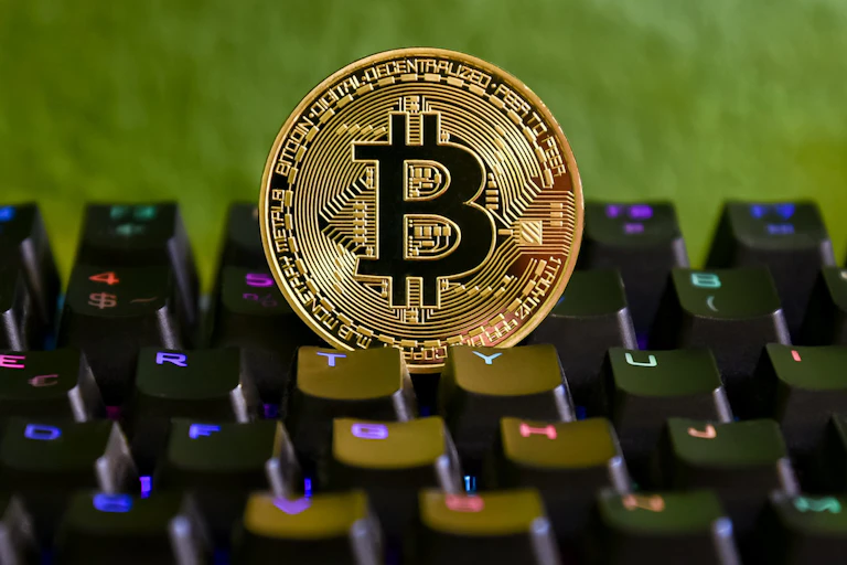 Pièce symbolisant un bitcoin sur un clavier d'ordniateur