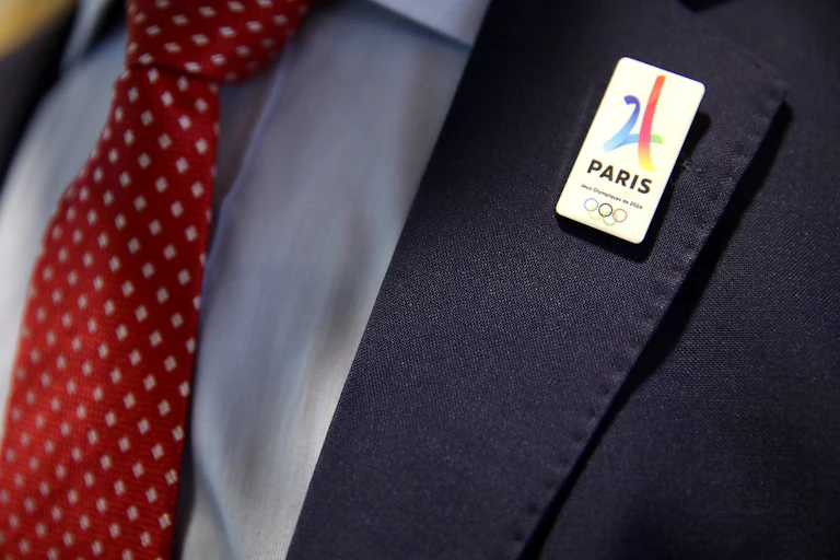Costume avec un pin's Paris 2024