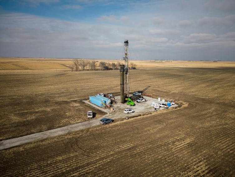 Una explanada de color amarillo por los cultivos con la maquinaria para perforar.