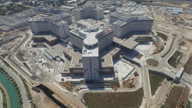 Overhead view of Adana Hospital, made up of several white and tan multistory buildings