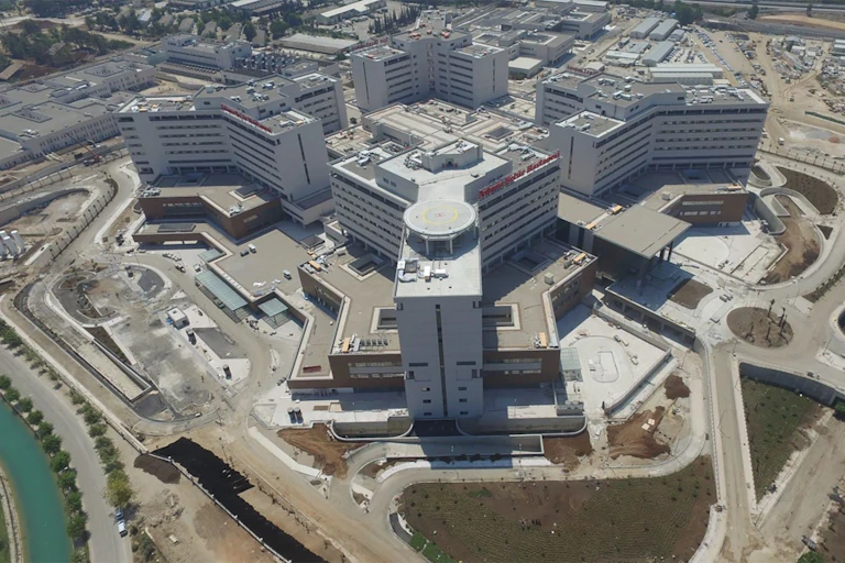 Overhead view of Adana Hospital, made up of several white and tan multistory buildings