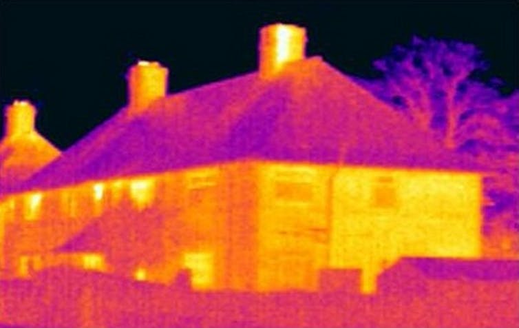 An infrared image of a house showing significant heat losses.