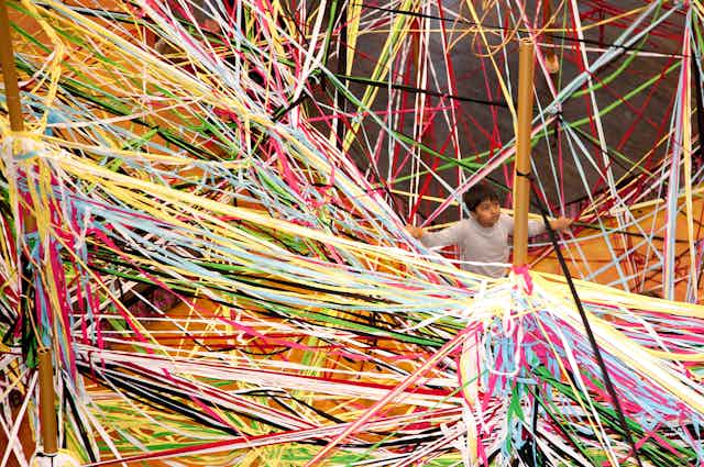 A young boy surrounded by ribbons