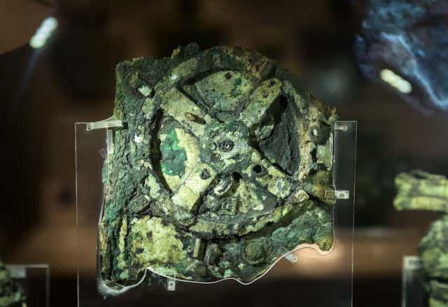 A stone looking roughly like a cog in various shades of green