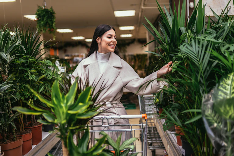 A woman choosing houseplants in a garden centre.