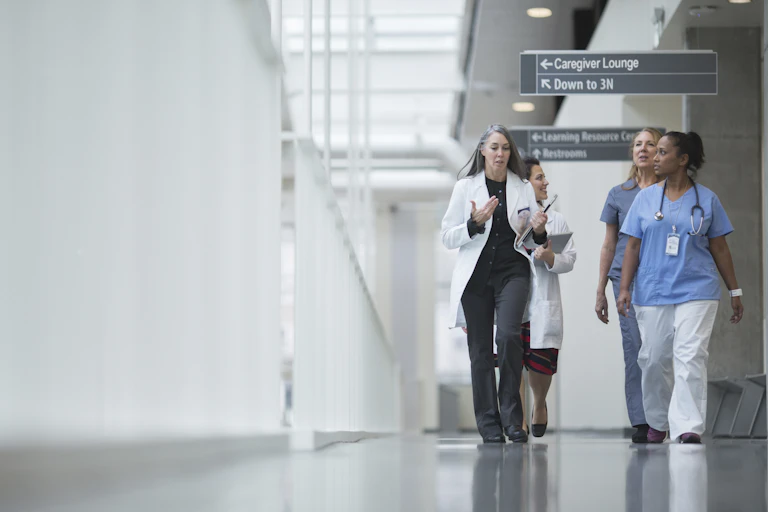 A group of female doctors walking down a hallway.