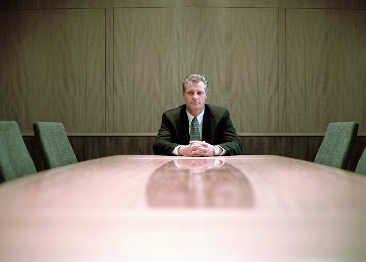 A man sitting at the head of a table.