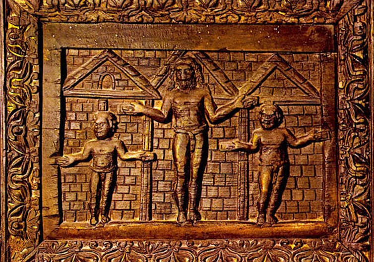 Carved wooden panel: Jesus appears to be nailed in a door frame.