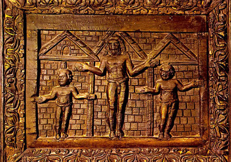Carved wooden panel: Jesus appears to be nailed in a door frame.