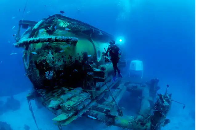 A photo of a diver in front of the Aquarius Habitat, an underwater habitat used by researchers.