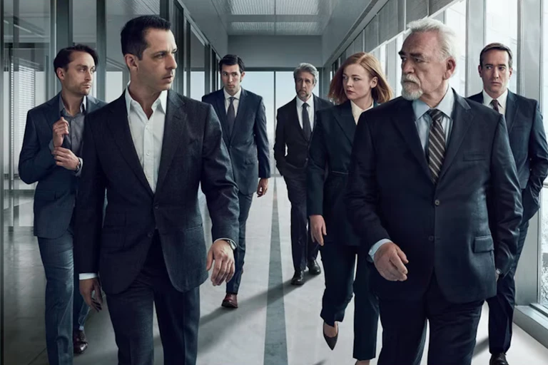 The cast of Succession walking down a corridor in black suits eyeing each other with suspicion.