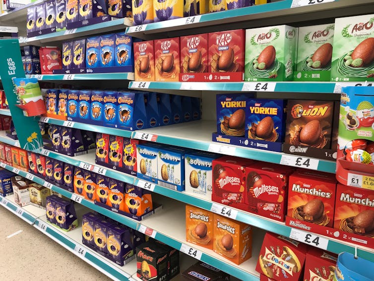 Supermarket shelves stacked with colourful Easter egg boxes.