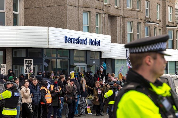 pro-refugee demonstrators and police outside of the front of Beresford Hotel