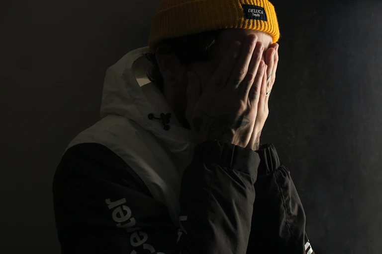 A man covers his eyes with his hands.