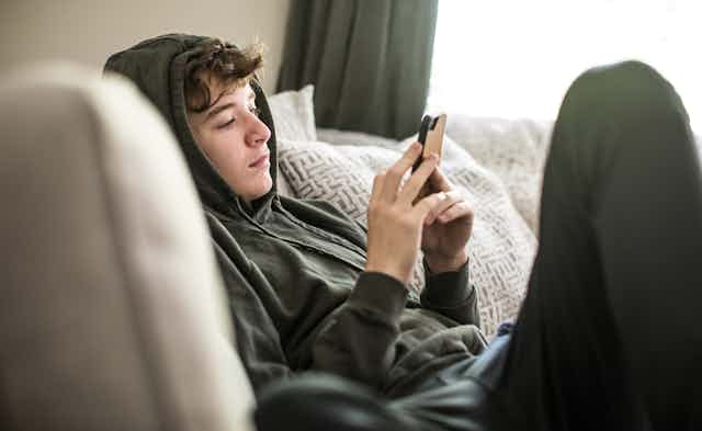Teenager using smartphone at home 