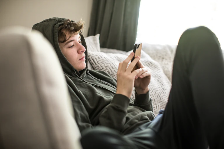 Teenager using smartphone at home