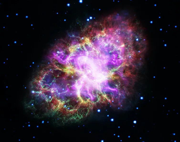 A bright, multi-coloured supernova remnant with dusty, wispy filaments and something resembling a tornado (the pulsar wind nebula) in the centre.