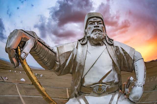 Statue of Ganghis Khan dressedd kin armour and carrying a sword.