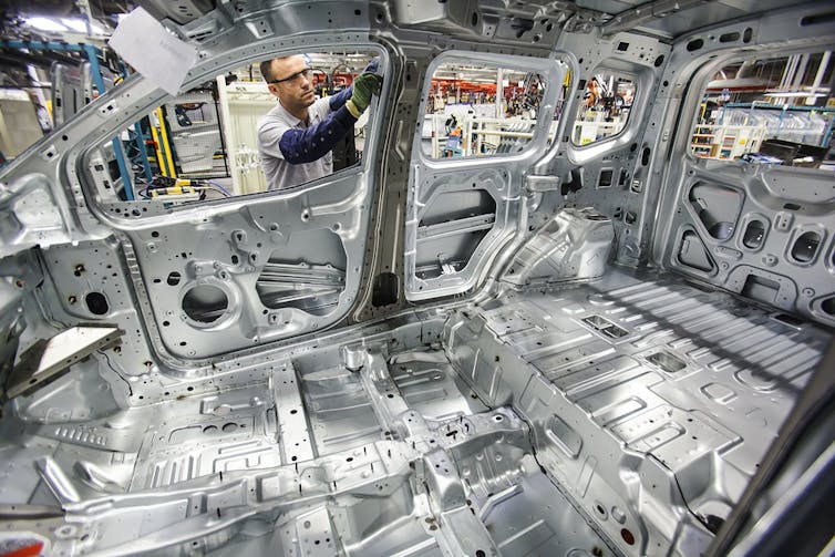 Engineer working on a Ford car in a factory