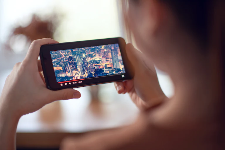 A person holding a smartphone watching a video.