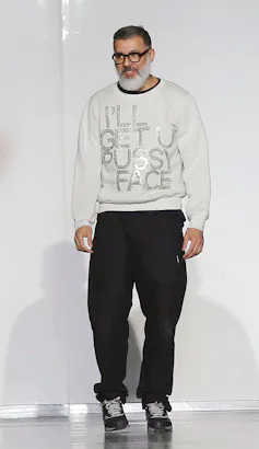 A bearded Ashish Gupta wears glasses and a sparkly white jumper.
