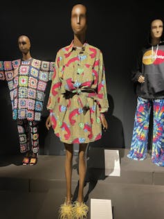 A colourful shirt dress hangs on a mannequin.