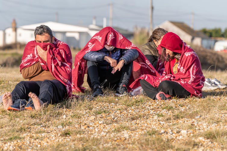 Family of migrants sheltering on a beach