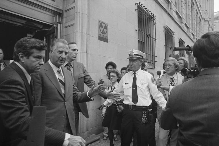 Surrounded by Secret Service agents, Spiro Agnew speaks to reporters outside a federal courthouse.