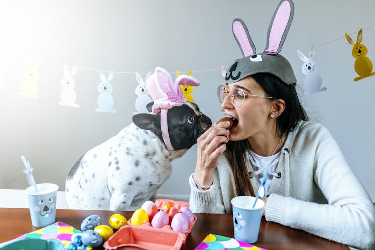 Dog and woman, both with Easter bunny ears on