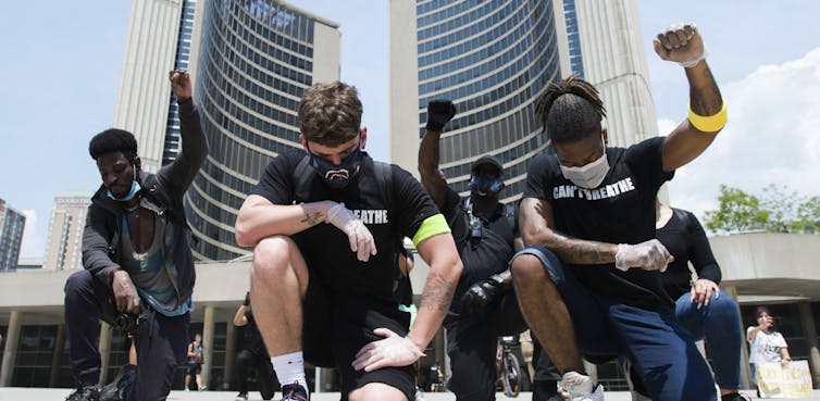 Protesters seen kneeling down in front of city hall.