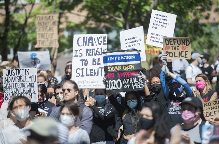A crowd of people seen holding signs.