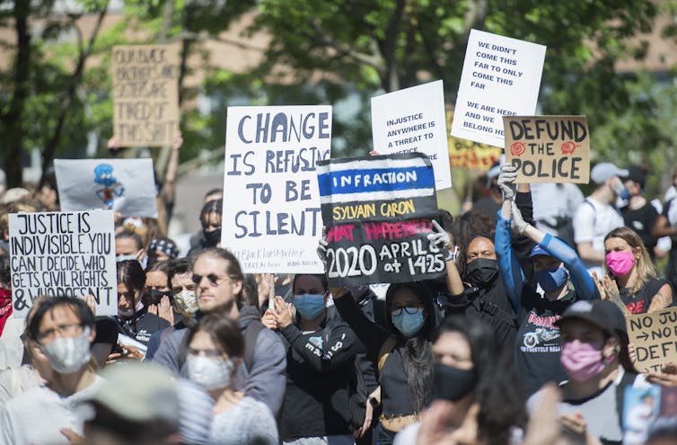 A crowd of people seen holding signs.