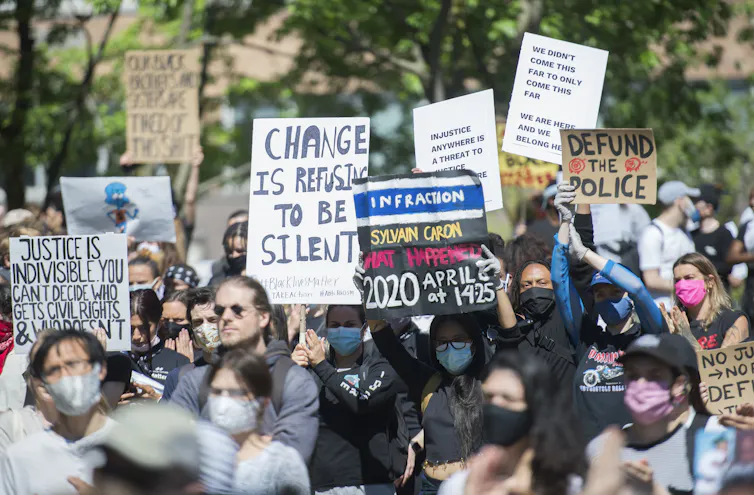 A crowd of people seen holding signs.