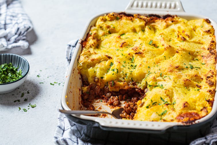 dish of freshly cooked pie with potato topping, one portion taken out