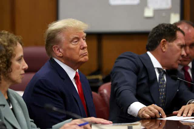 Donald Trump sits in a New York courtroom with his defence team.