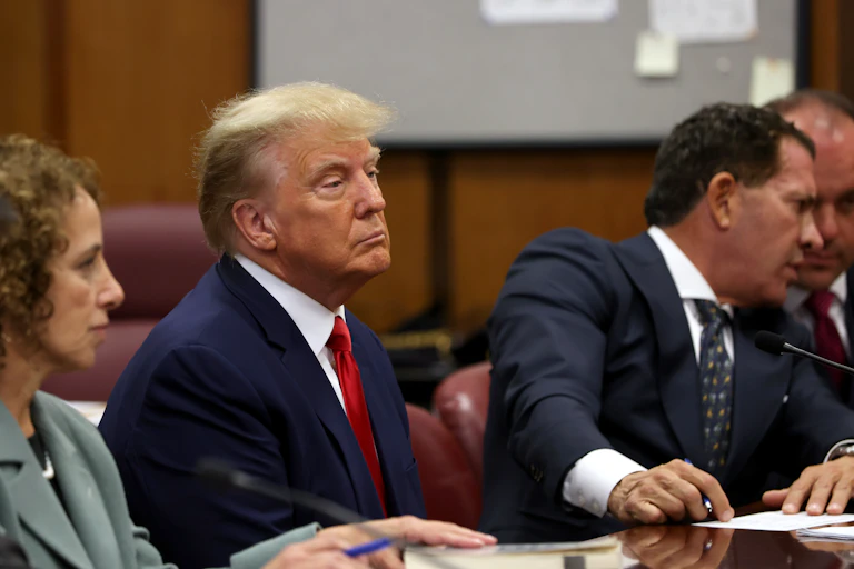 Donald Trump sits in a New York courtroom with his defence team.