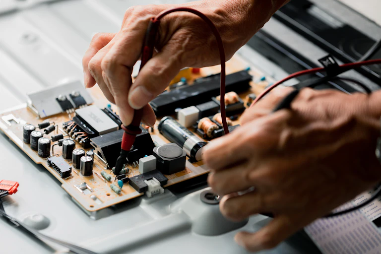 two hands work on a circuit board