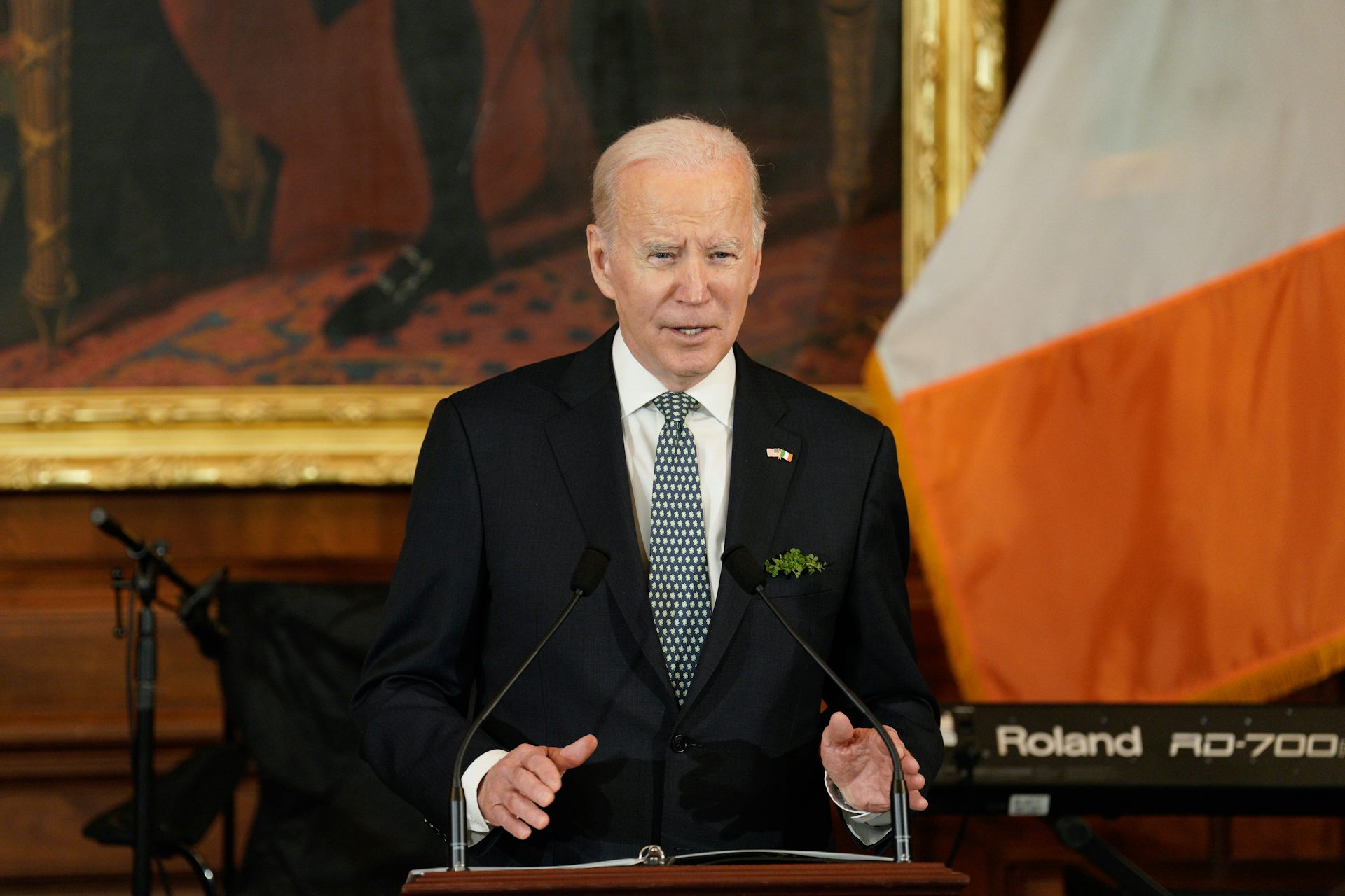 Joe Biden speaks at a podium in front of an Irish flag