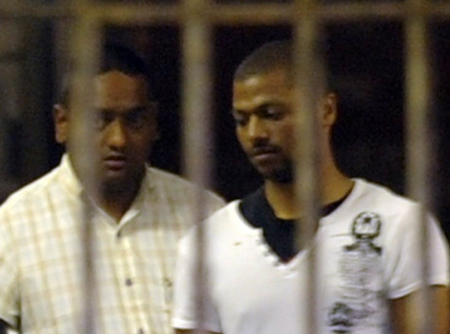 A grainy image of two men pictured behind jail bars.