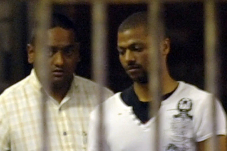 A grainy image of two men pictured behind jail bars.