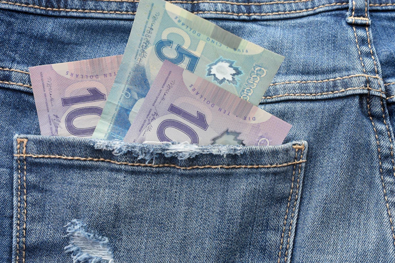 Canadian bills are seen in the pocket of a pair of jeans.