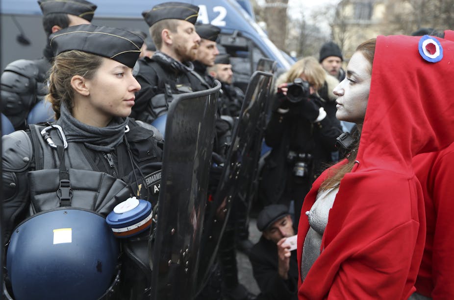 Femme gendarme faisant fasse à une manifestante habillée en "Marianne".