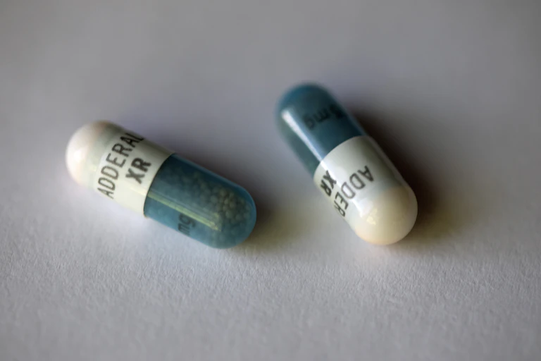 Two Adderall XR capsules displayed on a white background.