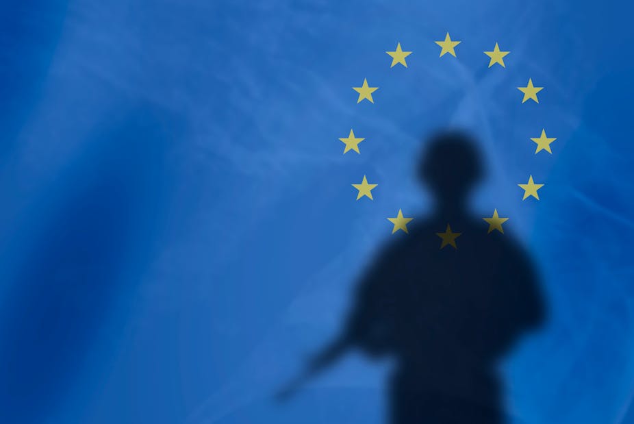 L’ombre d'un soldat sur fond de drapeau de l'Union européenne.
