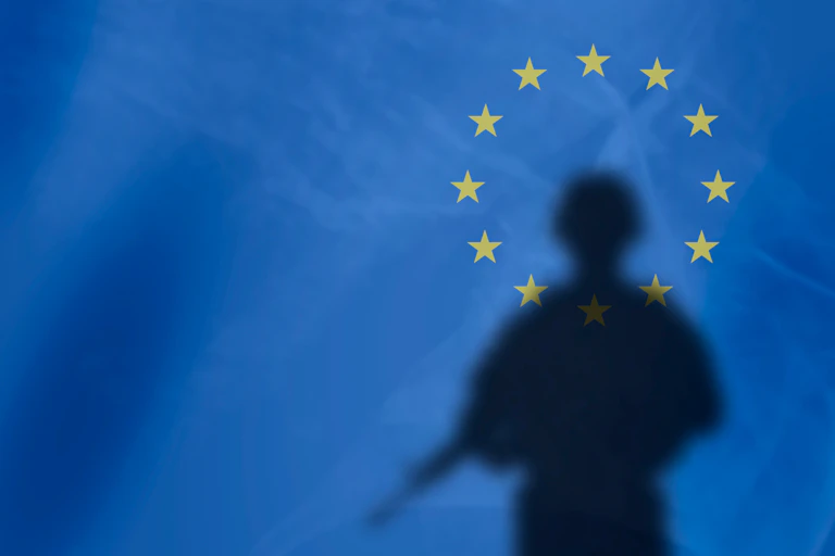 L’ombre d'un soldat sur fond de drapeau de l'Union européenne.