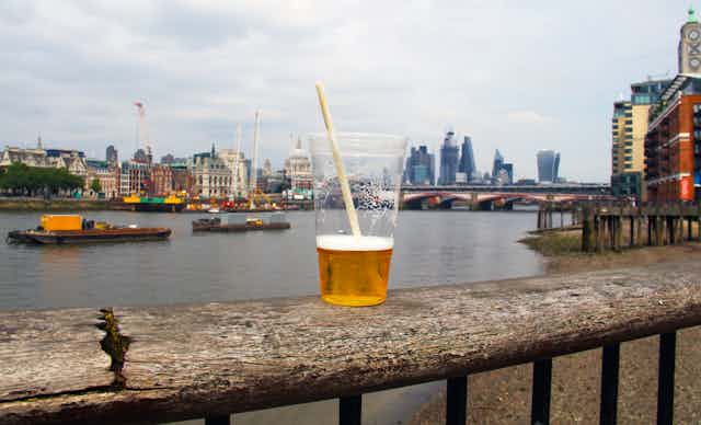 plastic cup of beer with london skyline in background