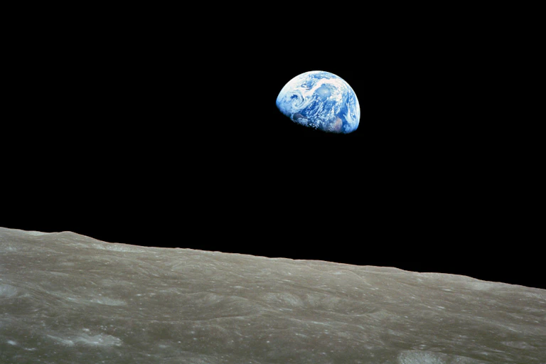 View of Earth taken from spacecraft with the Moon's surface in foreground.