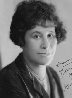 Black and white portrait of a woman smiling.