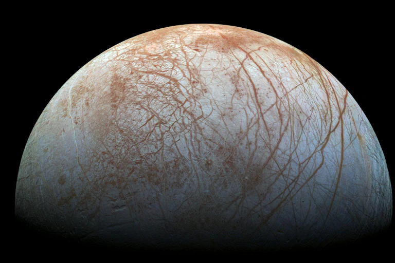 A grey round moon with rusty red streaks.