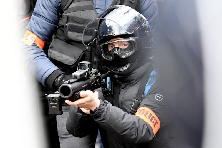 Un policier pointe son LBD lors d’une manifestation à Paris le 11 janvier 2020 contre le projet de réforme des retraites